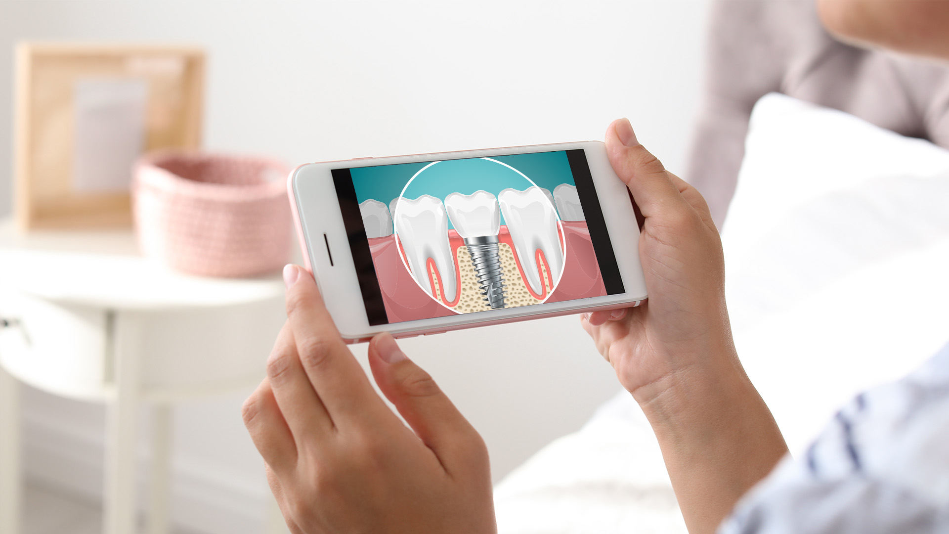 A person holding a smartphone displaying an image of a tooth with a zoomed-in view of the root.