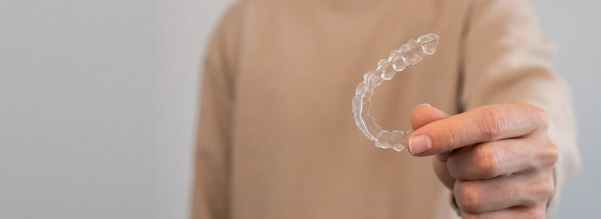 A hand holding a clear bubble with a reflection of a person.