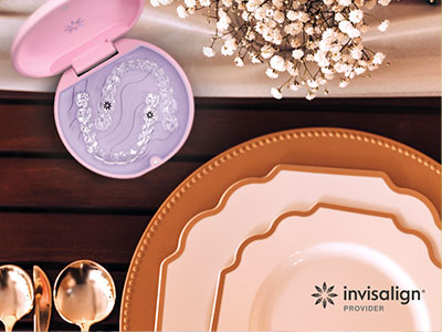 An advertisement for Invisalign products with a focus on oral care, featuring a close-up of an Invisalign aligner tray and a collection of dinnerware placed on a dining table.