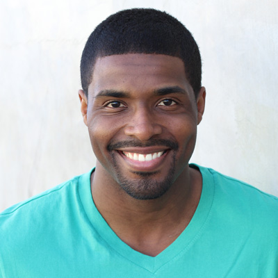 A man and woman are smiling, embracing each other while posing for a photo.