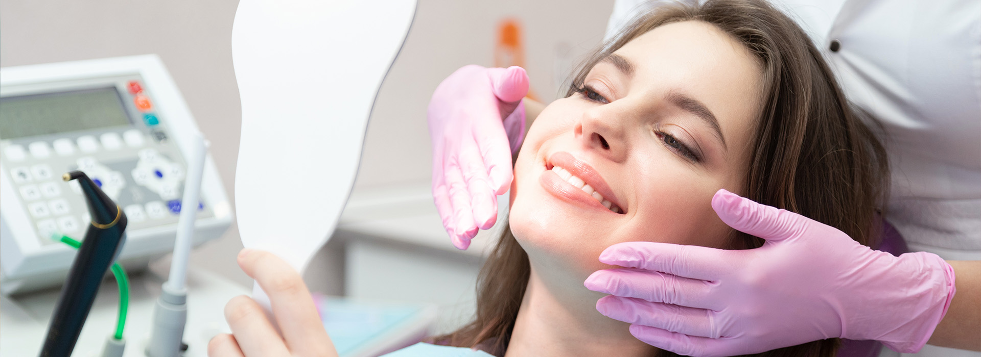 A woman receiving dental care, with a smiling expression, while seated in a dentist s chair.