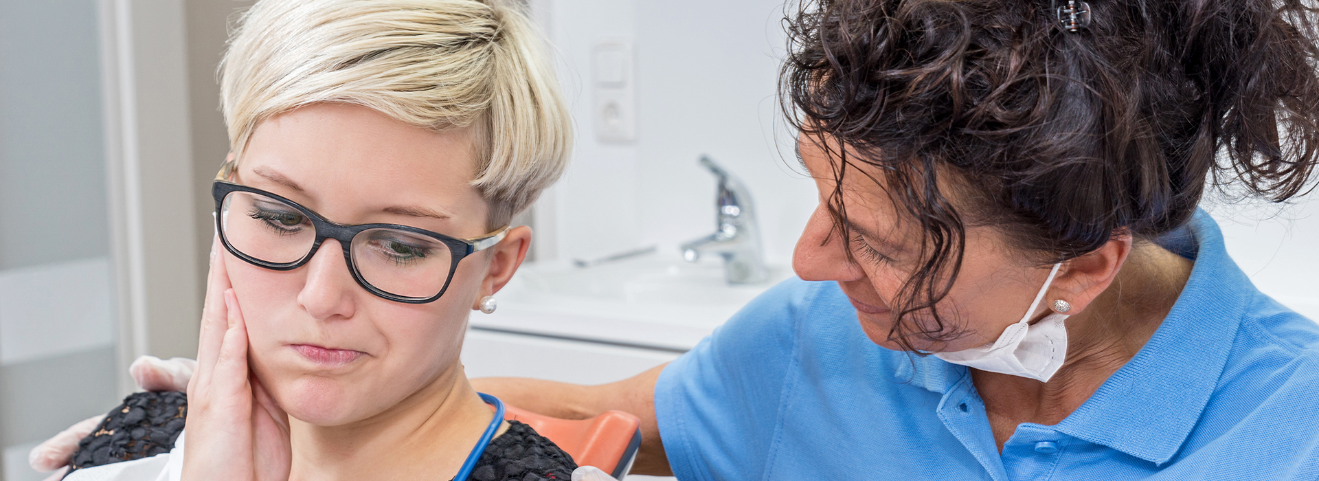 An image of a dental professional performing cosmetic work on a patient, with a focus on the use of a dental mirror.