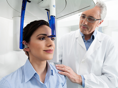 A person receiving a head scan in a medical facility, with a doctor guiding the process.