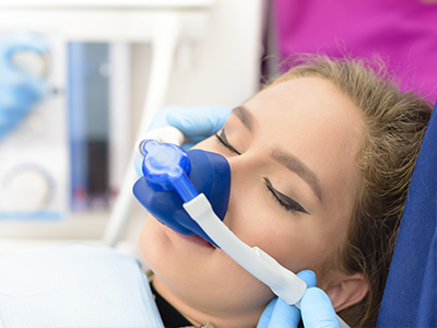 The image shows a person receiving medical attention, with a medical device attached to their face and a healthcare professional attending to them.
